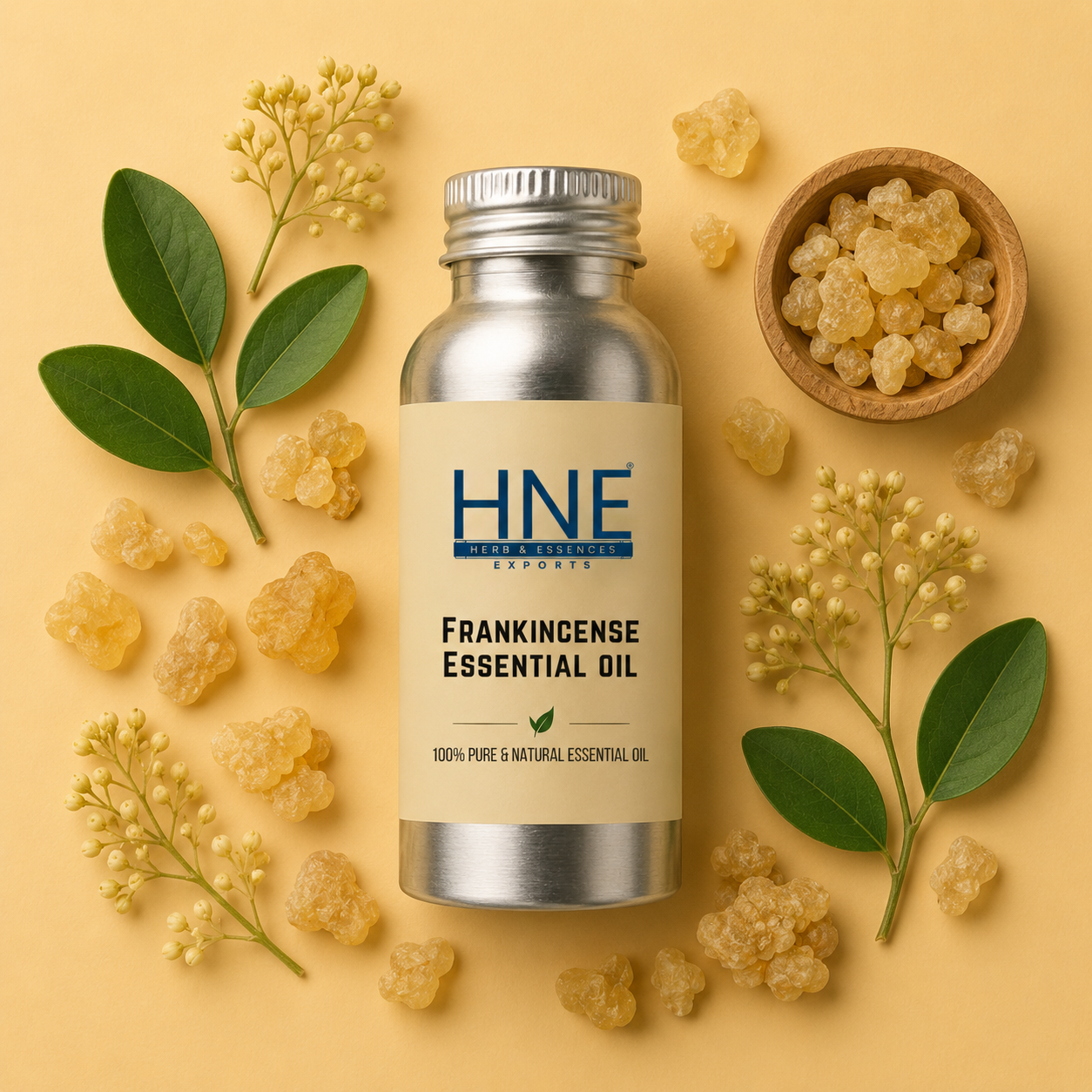 Frankincense essential oil bottle with frankincense resin and leaves on a yellow background
