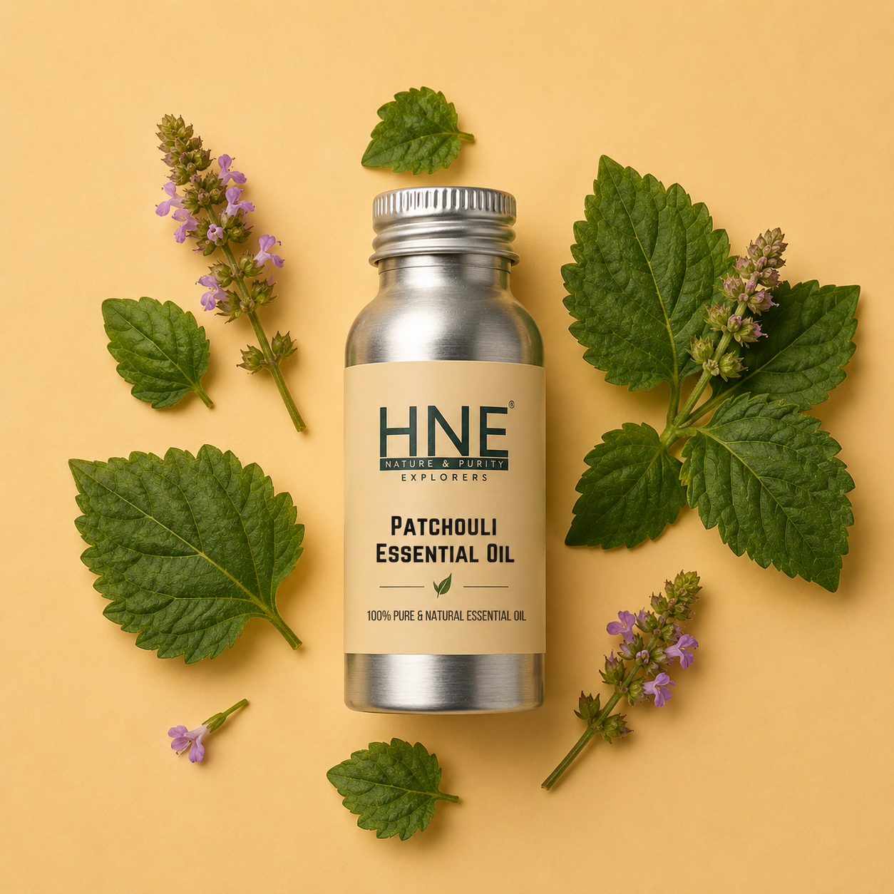 Bottle of HNE Patchouli Essential Oil surrounded by leaves and flowers on a beige background